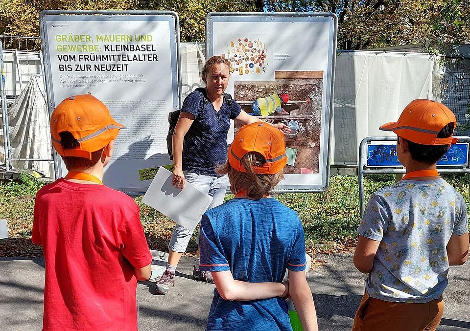 Kinder höhren der Archäologin zu